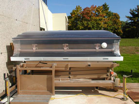 Casket wrapped in Franklin Wrap on lift