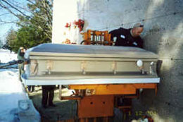 Casket wrapped in Franklin Wrap on lift